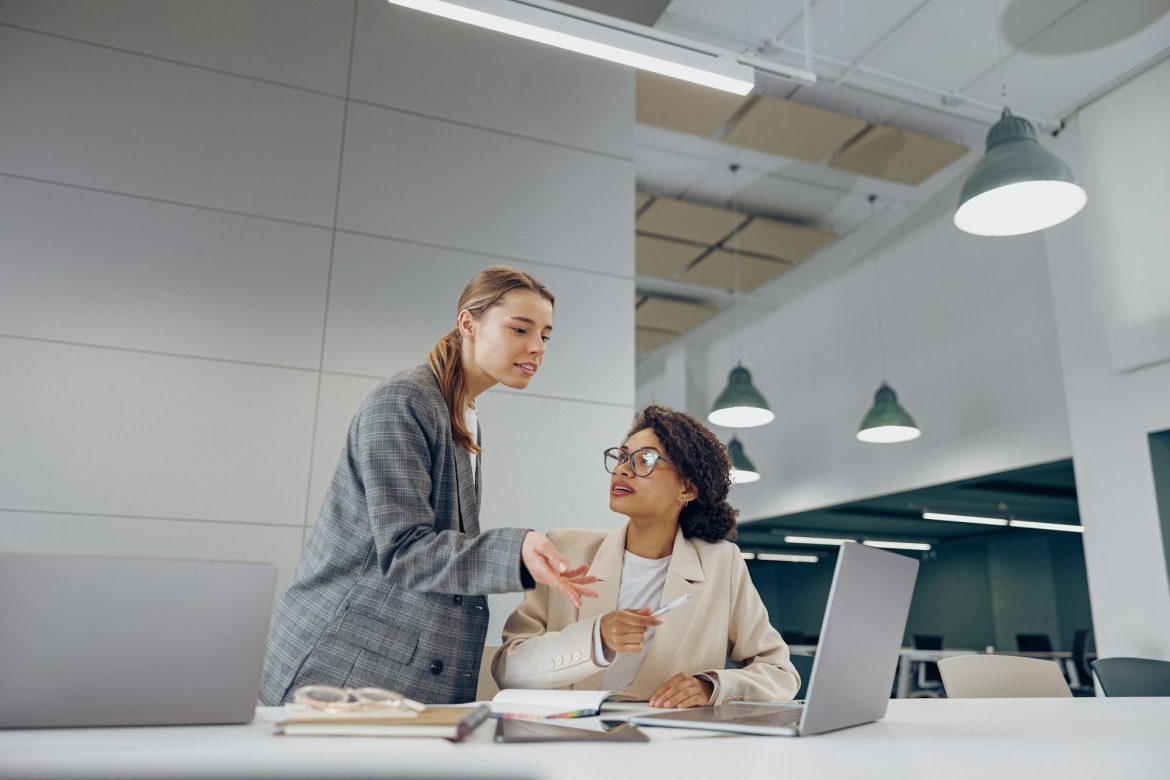 Two business woman work together to get the job done at the office and use