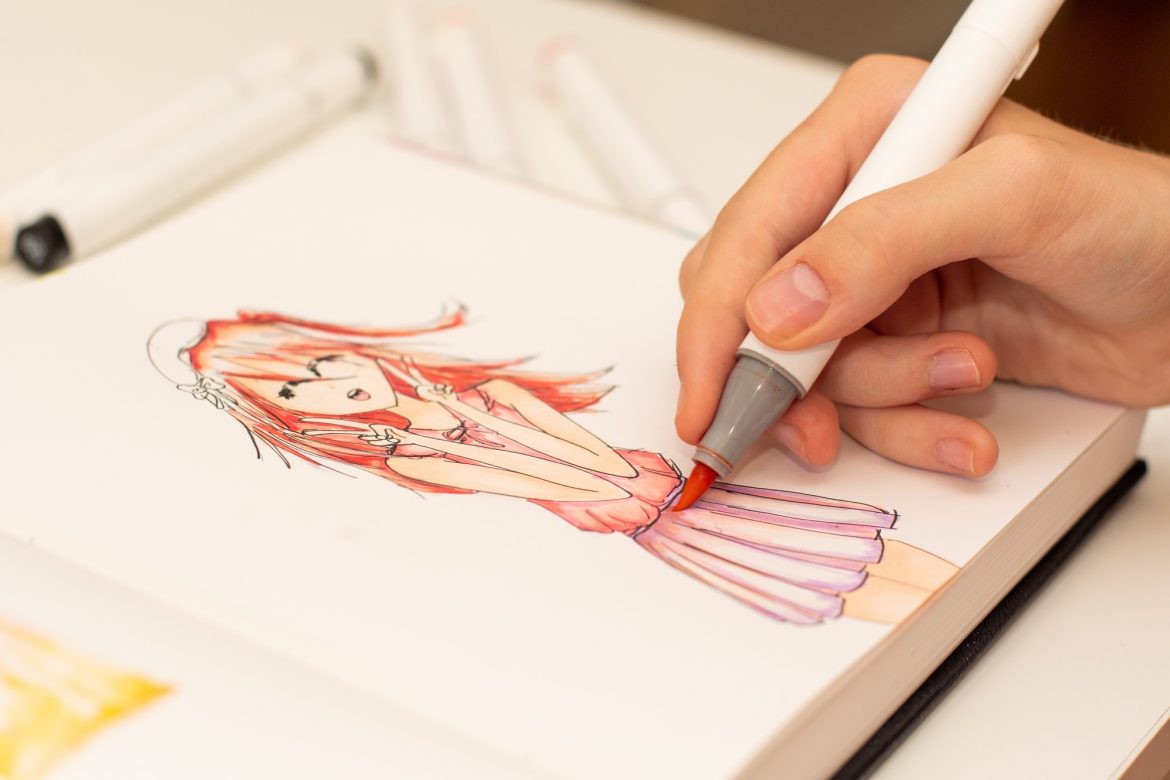Girl’s hand drawing anime manga sketch with alcohol based sketch markers. Girl's hand drawing anime manga sketch with alcohol based sketch markers.