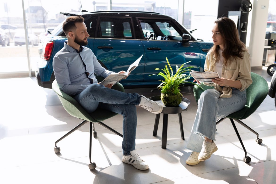 a young married couple picks up insurance for a car in a car dealership a young married couple picks up insurance for a car in a car dealership