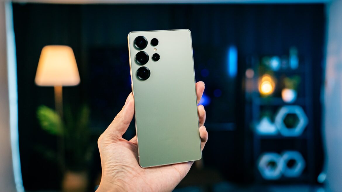 Photo by Amanz A person holding a cell phone in their hand