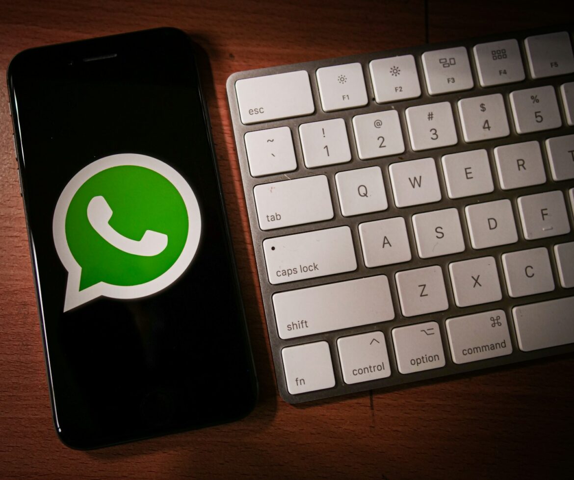 Photo by Grant Davies a phone with a whatsapp sticker next to a keyboard