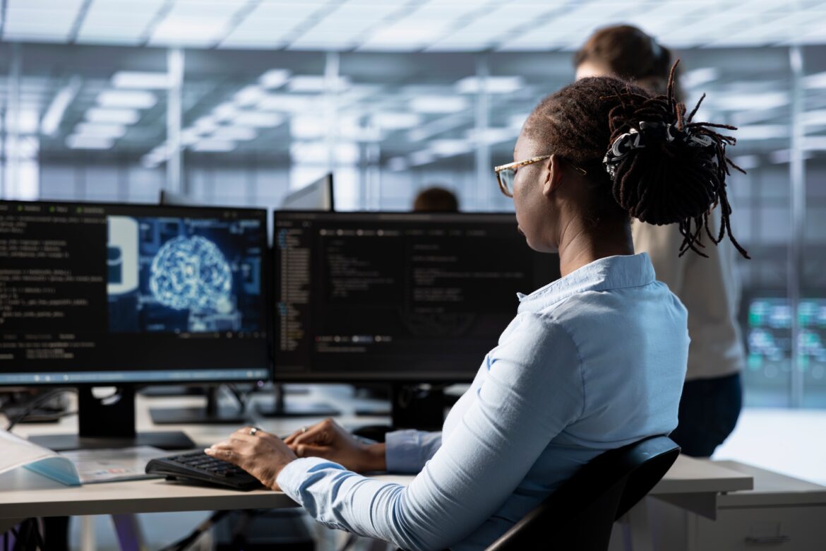 Engineer managing supercomputers in server room using AI tech