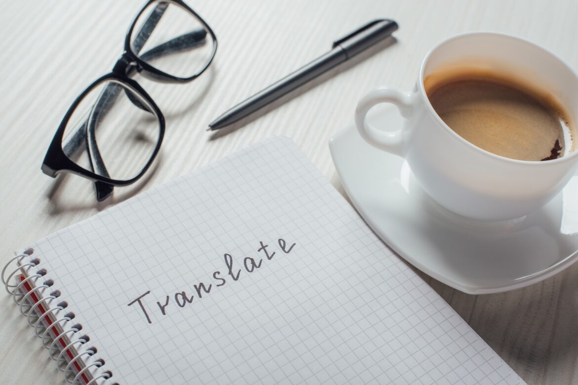 close up of coffee and notepad with word translate on workplace الترجمة التخصصية