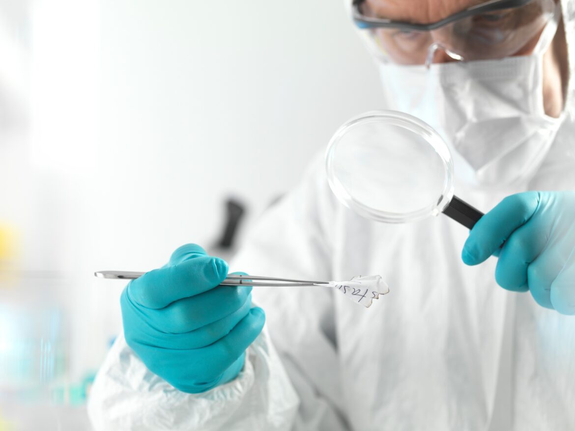 Forensic scientist examining fragments of paper in a laboratory