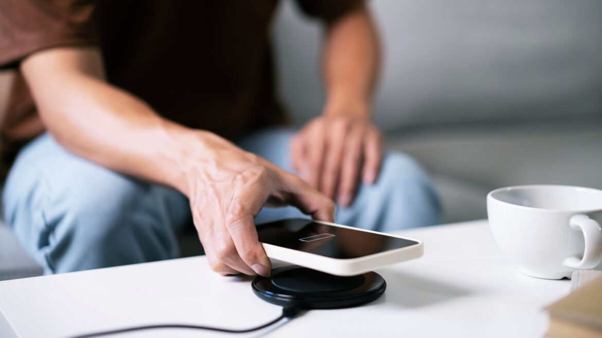 Charging mobile phone battery with wireless charging device in the table. Smartphone charging