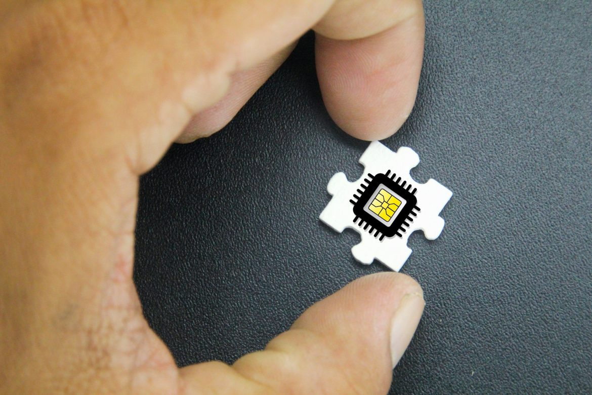 hand holding puzzle with microchip icon.