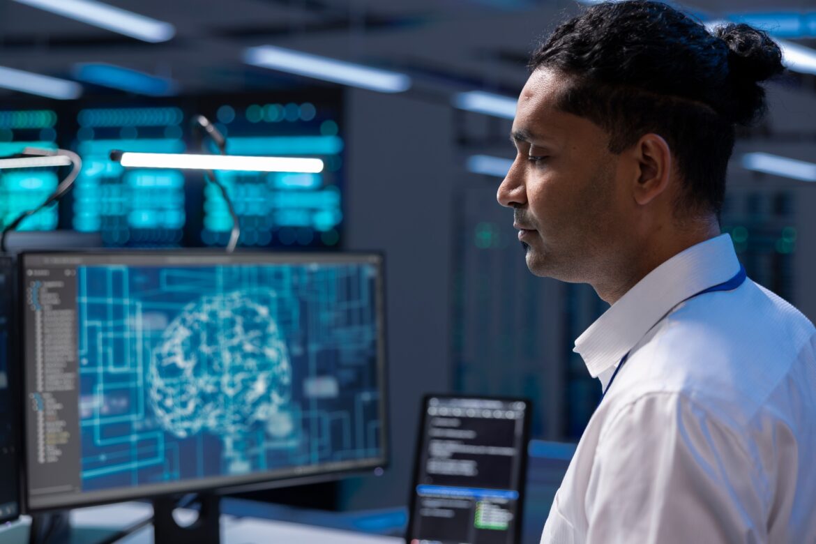 Programmer working on computer in data center with artificial intelligence