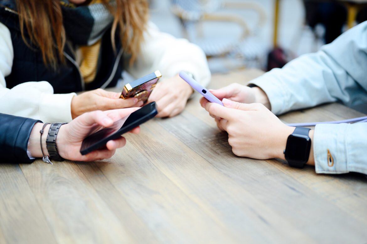 Three women with mobile phone, social media concept