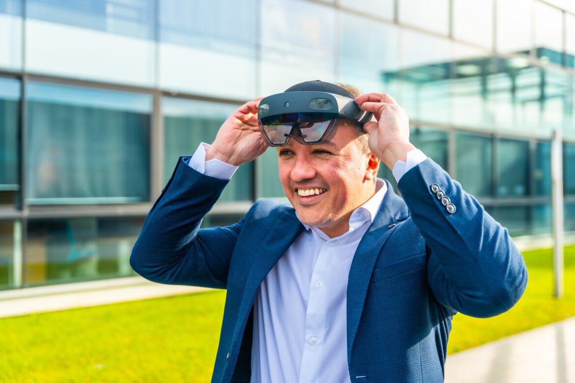 Businessman putting on virtual reality headset outdoors