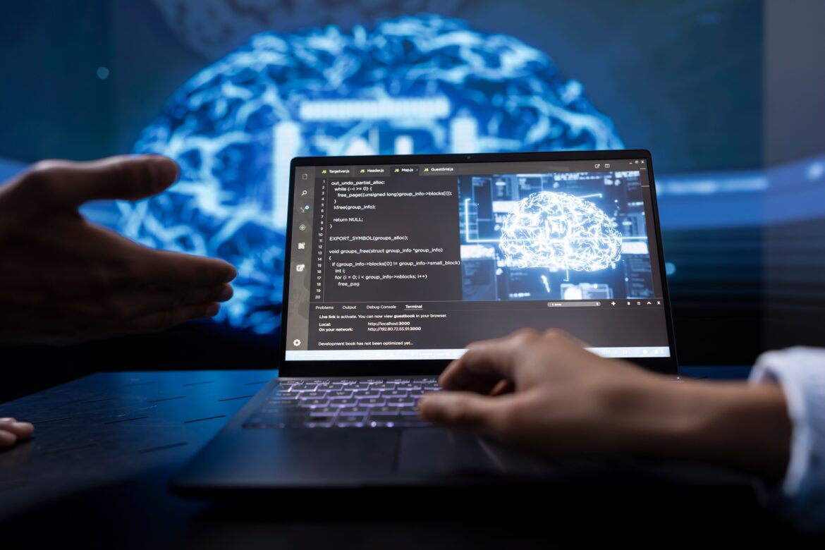 Close up of teamworking IT experts using artificial intelligence on notebook