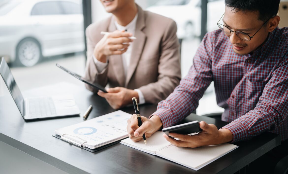 Businessman and team analyzing financial statement Finance task. with smart phone and laptop