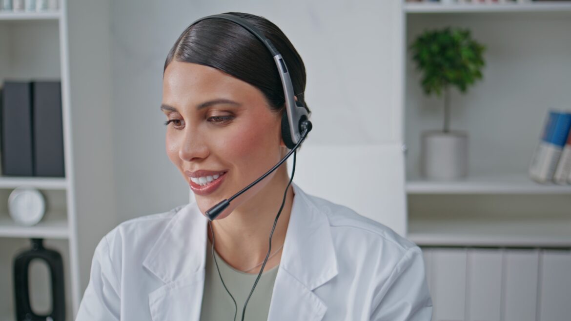 Smiling medic talking headset giving treatment recommendation at clinic closeup.