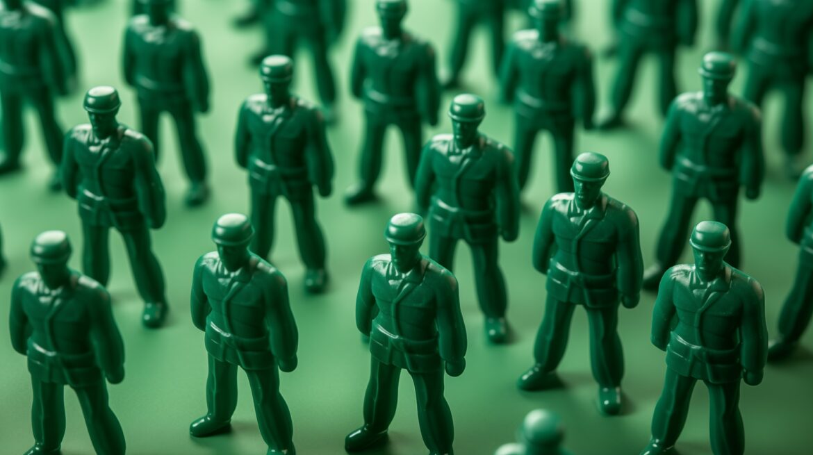 Plastic green army men in formation at attention.