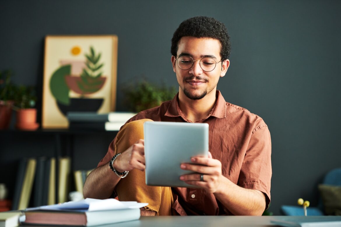 Young Middle Eastern male student looking at screen of tablet